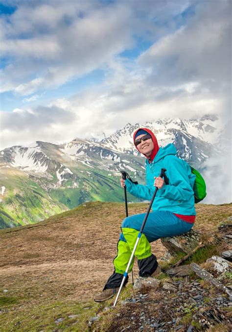 Young Happy Woman Hiker Sitting On The Top Of Mountain Stock Photo