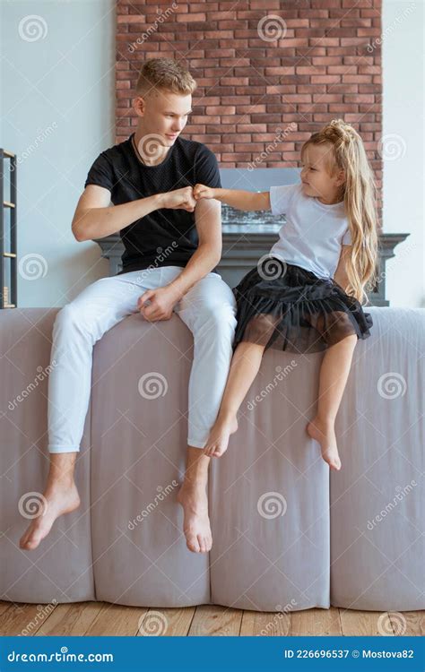 Caucasian Siblings Sitting On The Sofa In Loft Interior Stock Image