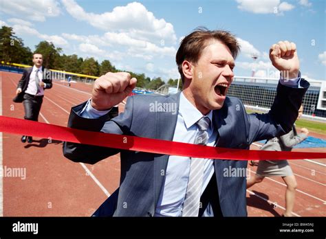 Photo Of Happy Businessman Crossing Finish Line During Race Stock Photo