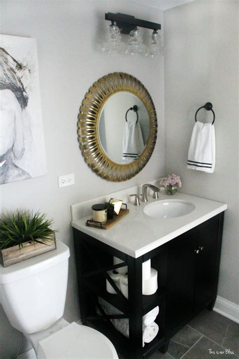 This elegant bathroom features black and white marble. How to Create a Neutral Glam Basement Bathroom | This is ...
