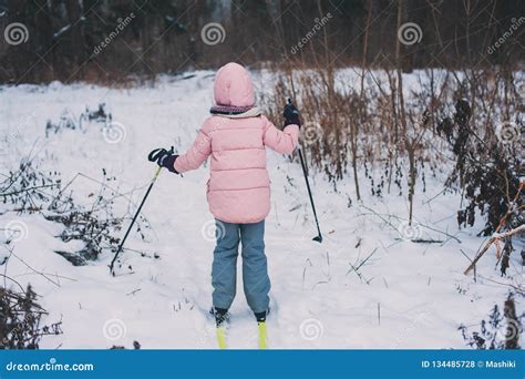 Happy Child Girl Skiing In Winter Snowy Forest Spending Holidays