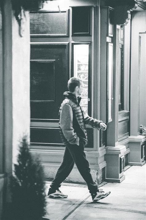 Man Walking On Sidewalk Near Building · Free Stock Photo