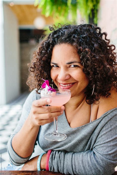 A Woman Drinking A Pink Cocktail With A Flower In It Del Colaborador De Stocksy Kristen