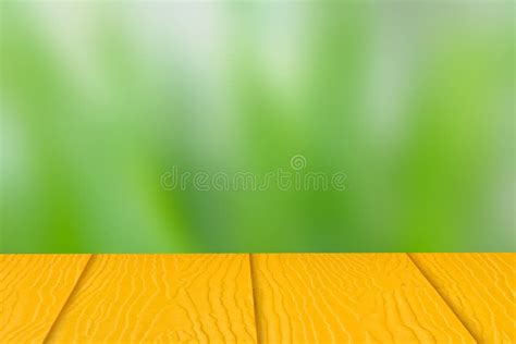 Empty Yellow Wooden Table On Green Nature Blurry Background Copy Space