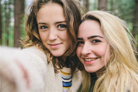 Two Teenage Girls Taking A Selfie In The Woods By Stocksy Contributor