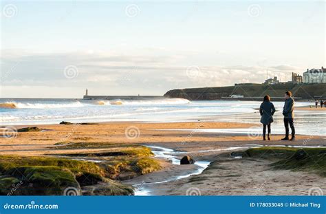 Panoramic View Of Couple Walking On The British Seaside At Sunset In