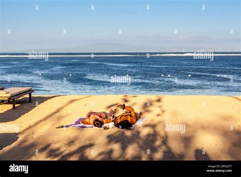 Visitors Sunbathing On The Beach Sanur Beach Bali Indonesia Stock