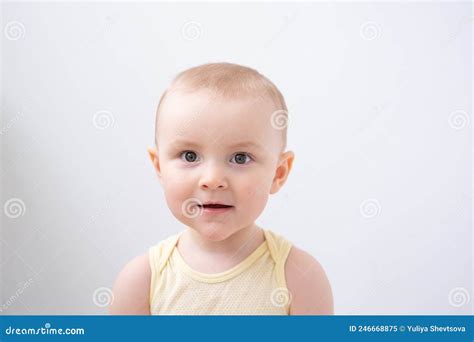 Portrait Of Cute Baby Boy With Brown Eyes In Yellow T Shirt On White