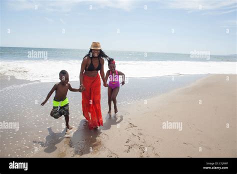 Mother And Children Walking On Beach Stock Photo Alamy