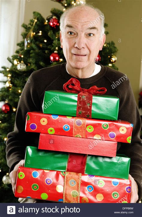 Puzzles and games that engage the brain offer numerous health benefits for elderly men and women. Elderly man with Christmas gifts Stock Photo: 61342705 - Alamy