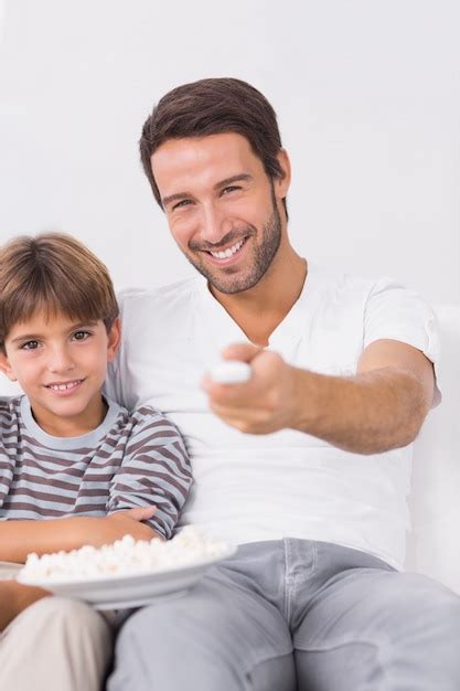 Sonriente Padre E Hijo Viendo La Televisión Foto Premium