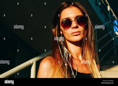 Young Woman With Long Brown Hair And Sunglasses On Stairway Head And