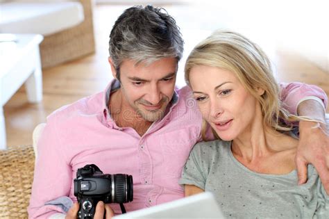 Mature Couple At Home Using Camera And Tablet Stock Image Image Of