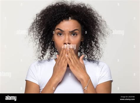 Shocked African American Woman Covering Mouth With Hands Stock Photo