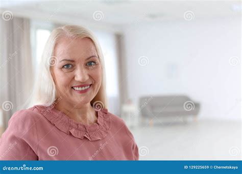 Portrait Of Beautiful Older Woman Against Blurred Background Stock