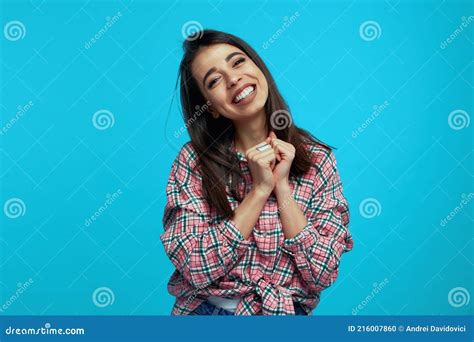 Optimistic Smiling Girl Clasps Hands Near Face Smiles Broadly Dressed In Casual Clothes
