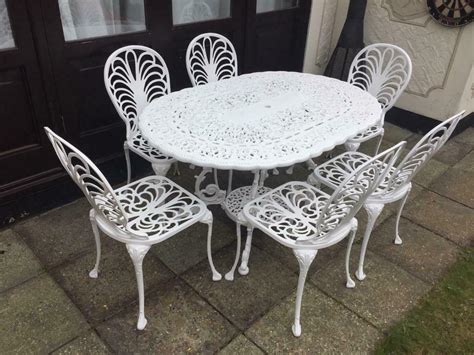 Wrought iron chair and table on sunny terrace. Stunning Vintage Cast Aluminium Style Patio Garden ...