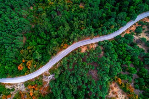 Aerial View Of Drone Over Mountain Road Going Through Forest Landscape