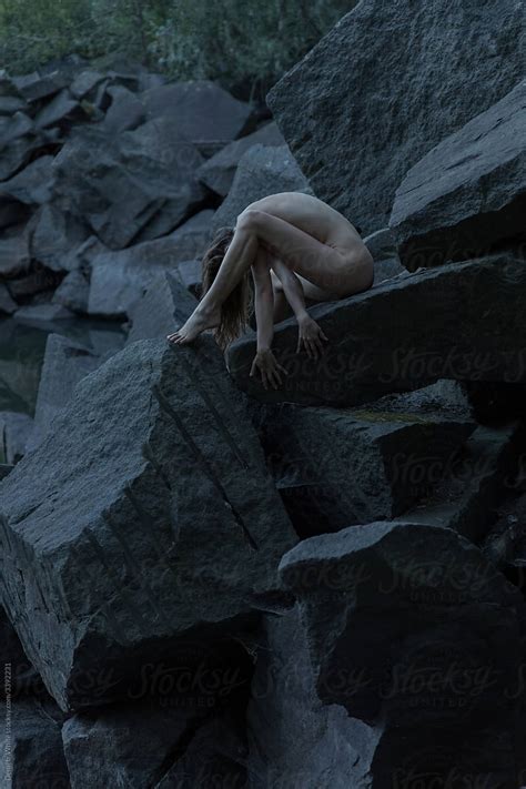 Naked Girl Sitting Naked And Posing Surrounded By Other Stones Del Colaborador De Stocksy