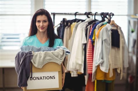 Les Vêtements Féminins Bénévoles Tenant En Boîte De Dons Photo Gratuite