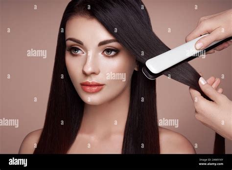Hairdresser Straightening Long Dark Hair With Hair Irons Beautiful
