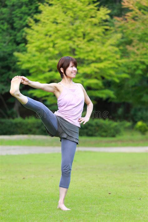 Japanese Woman Doing Yoga Extended Hand To Big Toe Pose Stock Image