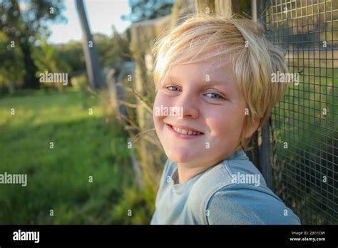 Blonde 10 Year Old Boy Relaxed And Happy Smiling On Farm Leaning