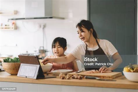 Asian Chinese Mother Teaching Daughter Cooking By Following