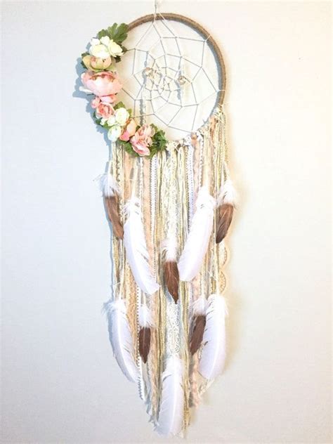 A Dream Catcher Hanging On The Wall With Flowers