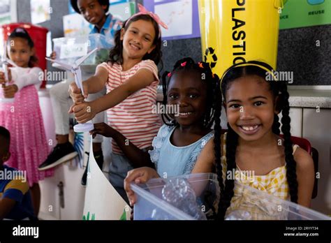 Portrait Of Happy Diverse Children With Ecology Items And Plants In