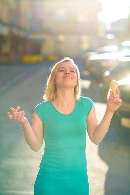 Premium Photo Young Beautiful Woman In Dress Eats Ice Cream On The