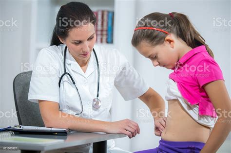 Doctor Checking Stomach Of Sick Girl Stock Photo More Pictures Of
