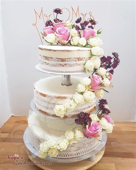 A Three Tiered Wedding Cake With Pink And White Flowers