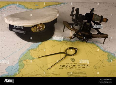 ein sextant marine uniform mütze und navigation teiler auf einem kartentisch auf der brücke