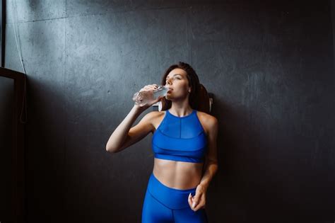 Free Photo Fit Woman Posing On The Camera Girl Drinks Water From A