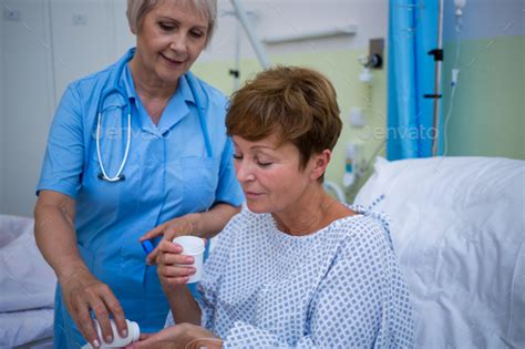 Nurse Giving Medication To Patient Stock Photo By Wavebreakmedia
