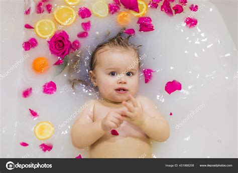 Nettes Kleines Mädchen Das Der Badewanne Mit Milch Und Orangefarbenen Stockfotografie