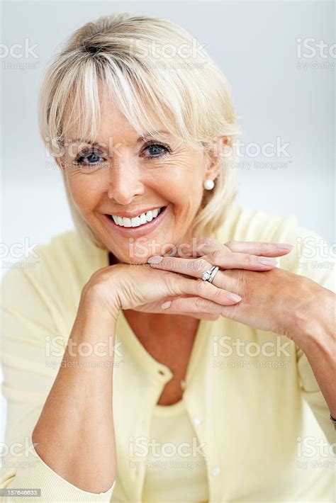Happy Mature Woman Smiling With Hands On Chin Stock Photo Download