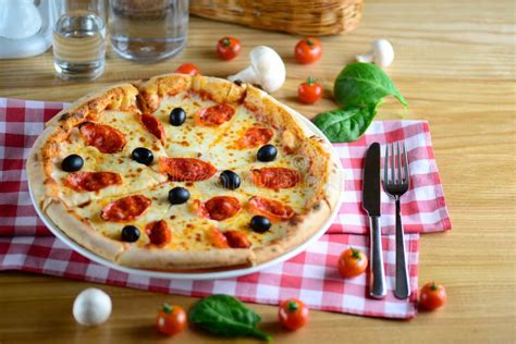 Neapolitan Hot Pizza With Pepperoni Mozzarella Cherry Tomatoes And Black Olives Served On A