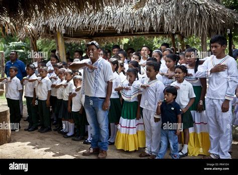 Los niños hondureños y líderes educativos cantar su himno nacional en la escuela primaria de