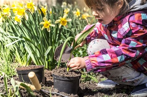 Niña Plantando Flores En El Jardín Día De La Tierra Niño Ayudando En