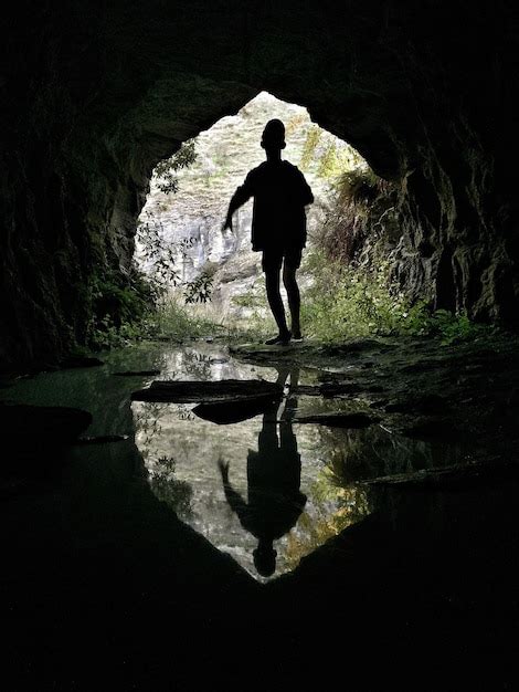 Premium Photo Silhouette Of Boy Standing In Cave
