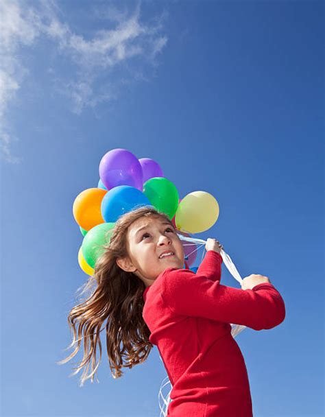 50 Little Girl Being Blown Away While Holding Bunch Of Balloons Stock
