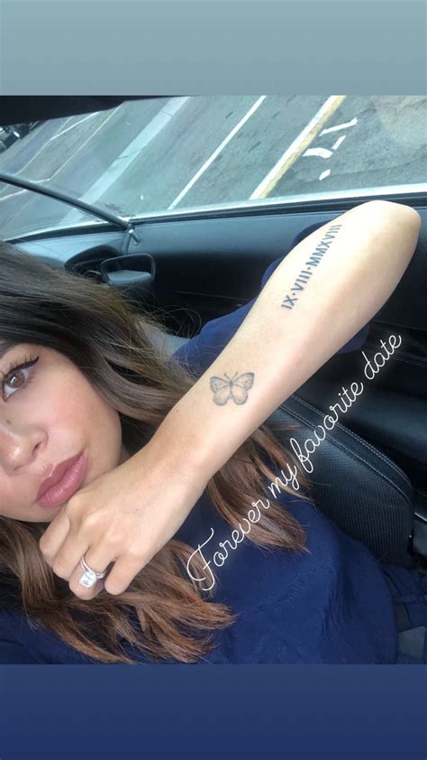 A Woman With A Tattoo On Her Arm Sitting In A Car Looking At The Camera