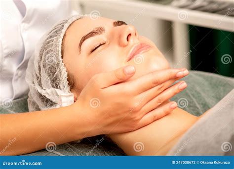 Facial Massage Hands Of A Masseur Massaging Neck Of A Young Caucasian Woman In A Spa Salon The