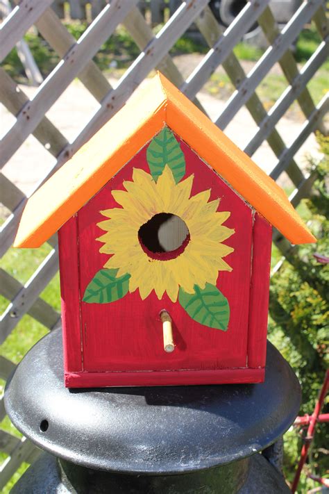 A Birdhouse With A Sunflower Painted On It