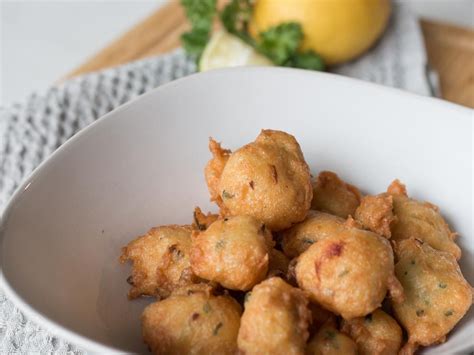 A white bowl filled with fried food on top of a table