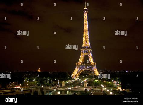 The Eiffel Tower Lit Up At Night Located On The Champ De Mars In Paris