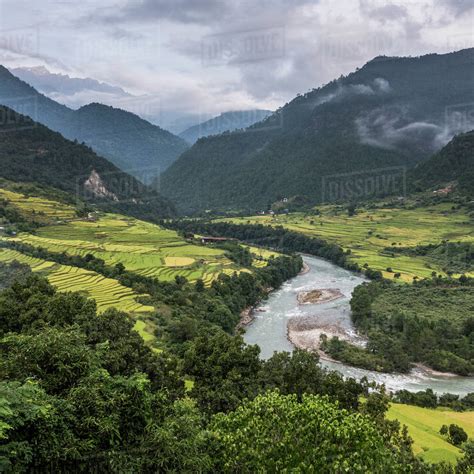 A River Flowing Through A Valley With Lush Farmland Surrounded By