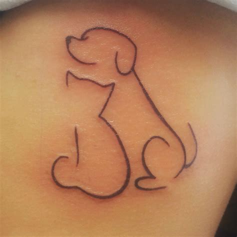 A Dog Tattoo On The Back Of A Womans Shoulder With An Outline Of A Dog